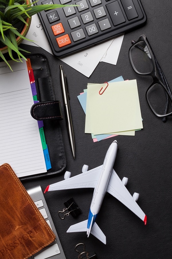 Concept de voyage d'affaires. Accessoires sur la table du bureau. Clavier de PC, passeport, calendrier et jouet d'avion.