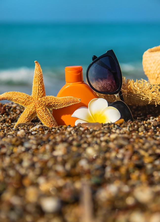 Crème solaire et lunettes sur la plage