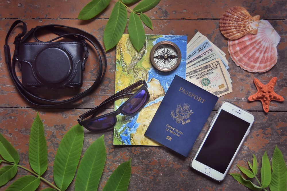 Vue du dessus d'un téléphone, appareil photo, boussole, carte, passeport avec décoration accessoires voyage plage