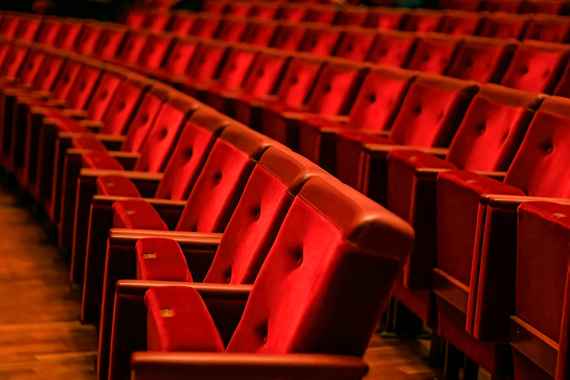 rows of red velour chairs in the auditorium of the opera